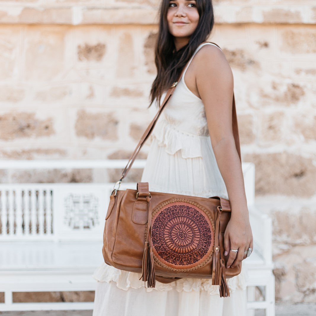 Close up of brown handmade leather purse. Stylish woman wearing white  dress, belt, holding handbag by red berries outdoors. Casual boho female  accesso Stock Photo - Alamy